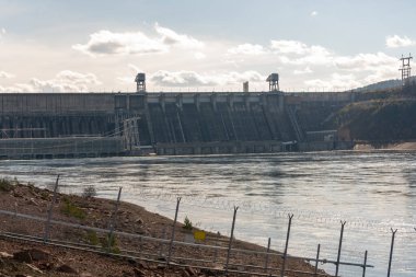 Rocky Nehri kıyısı hidroelektrik santralinin arka planında.