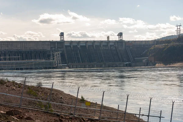 Rocky Nehri kıyısı hidroelektrik santralinin arka planında.