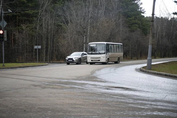 Autobus i samochód są na skrzyżowaniu wiejskiej drogi.. — Zdjęcie stockowe