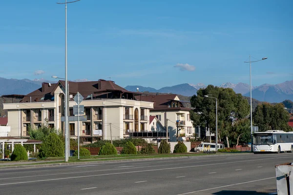 The road of the resort town against the backdrop of mountains and blue sky. — Zdjęcie stockowe