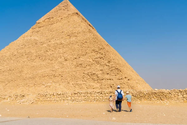 Padre e figli camminano davanti alla piramide di Chefren sull'altopiano di Giza — Foto Stock