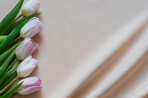 Bouquet primavera di tulipani rosa su tessuto beige con pieghe — Foto Stock