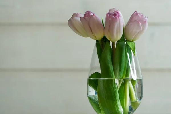 Bouquet primavera di tulipani rosa in vaso di vetro su sfondo di legno — Foto Stock