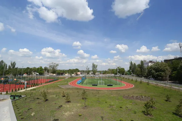 Sztuczna trawa na boisku, na stadionie szkolnym. Piękne niebo z chmurami. — Zdjęcie stockowe