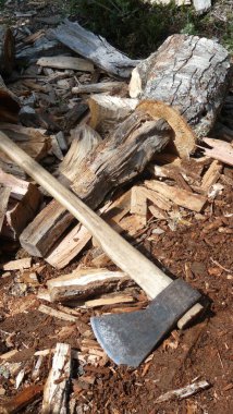 Tahta yığınının üzerinde yan yatan bir balta.