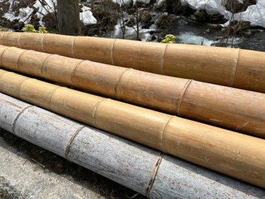 Four large brown bamboo poles 