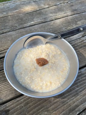 Spoon and bowl of plain porridge topped with umeboshi plum paste