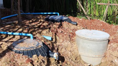 Siyah Foseptik Tankı. Plastik foseptik tankı ve beton boru toprağa gömülü ve PVC boru da açık hava inşaat alanındaki atıkları fotokopi alanı ile tedavi etmek için birbirine bağlı. seçici odak
