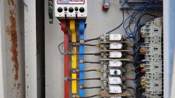 Equipment in an old metal control cabinet. Close up details of the electrical circuit system with a set of fuses and a circuit breaker for controlling the street lights. Selective focus