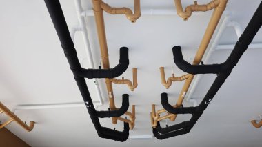 Binanın altındaki su borusu sistemi. Beyaz çimento tavan arka planındaki binalara hijyenik boru tesisatı kurulumu. seçici odak