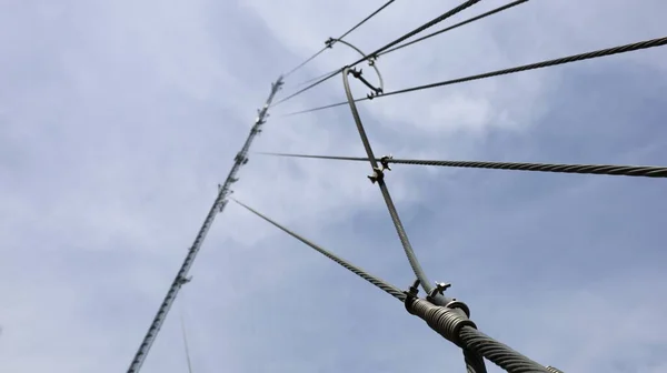 ケーブルと地上線ストレッチ電気通信塔 コピースペースと白い曇りの空の背景に雷保護のために接続されたサポートされているケーブルと地上線 選択的焦点 — ストック写真