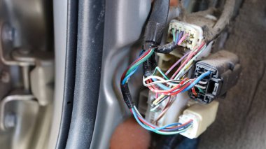 Arabalardaki kirli kablolar. Arabanın kapısında kopyalanmış kablolar ve bağlantı noktaları olan tozlu renkli kablolar. Seçici odak