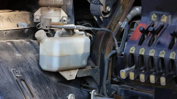 Kamyon soğutucu tankı. Yan radyatör sisteminde soğutucu bulunan beyaz plastik tankın motor parçalarının arka planında fotokopi alanı olan bir kaldıraç sistemi var. Yaklaş ve konuya odaklan.