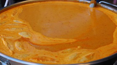 Kavanozda kırmızı köri ezmesi. Büyük paslanmaz çelik bir tencerede köfteli Tayland baharatlı kırmızı köri. Yaklaş ve konuya odaklan..