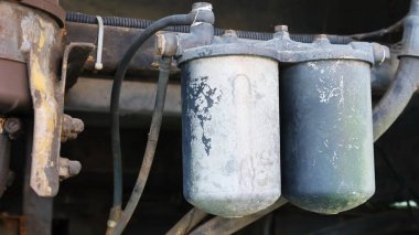 Old double oil filter. Twin pack bus diesel filter peeling and dirty paint on dark background with copy space. Selective focus