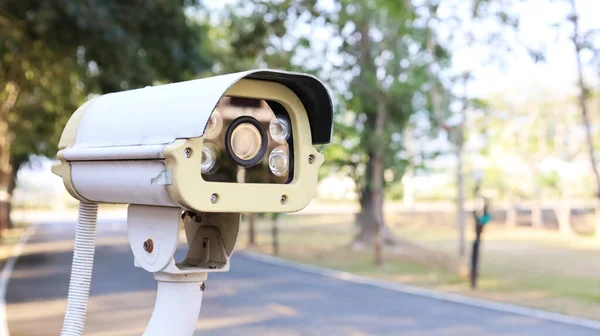 CCTV kameralarına yakın çekim. Yol kenarındaki güvenlik kameraları sokak arkasındakiler ve fotokopi alanı olan bulanık ağaçlar için. Seçici
