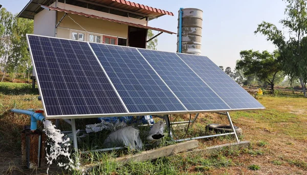 清洁的太阳能电池板抽水 光伏电池从太阳中产生清洁能源 在农庄的小木屋和水箱的背景下泵送地下水 有选择的重点 — 图库照片