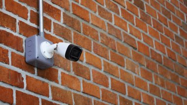 Kırmızı tuğladan bir duvarda CCTV var. Dükkanınızda ya da ofisinizde kopyalanmış CCTV 'li aksilikleri izlemek ve önlemek için modern teknoloji. Seçici odak