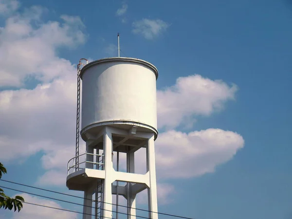 White concrete water tank on the tower.  large outdoor public water storage tanks for water supply in villages or communities in the city On the sky background with copy space.