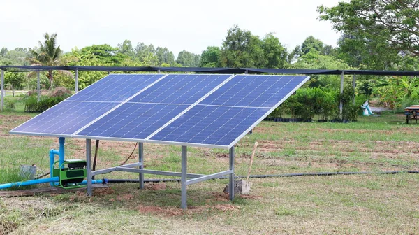 太阳能电池板和水泵 光伏抽水机的太阳能电池板 在绿色植物的背景下向农田供水 具有复制空间 有选择的重点 — 图库照片