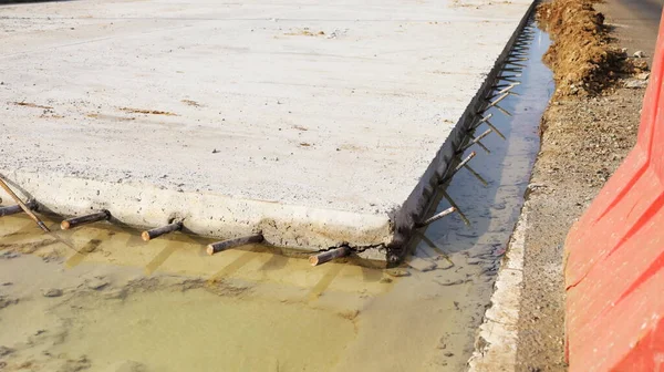 コンクリート路面の強化 道路建設地域に浸水したコンクリート床の横にある鉄棒の閉鎖 選択的焦点 — ストック写真