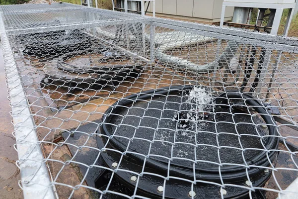 Kanalizasyon pompalama istasyonunu pompala. Sualtı Pompası, yağmur suyu ya da lağım suyu boşaltmak için metal kafeslerde beton tankların üzerinde çalışıyor. Seçici odak