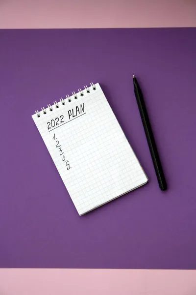 2022 notebook mockup on purple background. New Year. Plans, goals for 2022, space for text in a notebook.