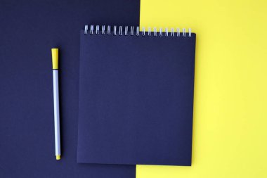 Mockup planlayıcı düz, üst yatay görünüm sarı ve siyah arkaplan. Kalemli siyah not defteri. Metin için boşluk