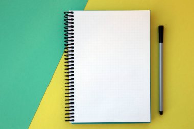 Planlayıcı düzeni, tasarım, harf, metin ve şablon için boş spiral defter aç. Sarı, yeşil arka plan, kalem. Metin için boşluk