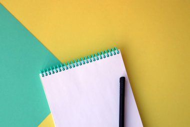 Planlayıcı düzeni, tasarım, harf, metin ve şablon için boş spiral defter aç. Sarı, yeşil arka plan, kalem. Metin için boşluk