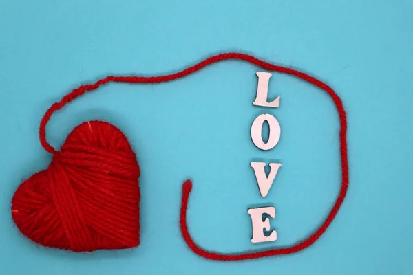 バレンタインデーのコンセプト 木製の文字青の背景に赤い糸で作られた愛と心 最上階だ 平置きだ モックアップ — ストック写真