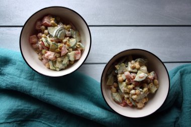 Nohut, domates ve salatalık. Beyaz kasede salata. Mutfak arka planı.