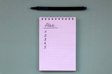 Yeşil arkaplan üzerine plan listesi olan defter ve kopyalama alanı olan kalem. Beyaz not
