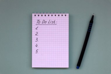 Yeşil arkaplan listesi ve kopya alanı olan kalem içeren bir defter. Beyaz not