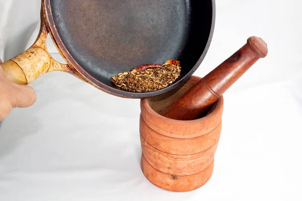 heated five spices pouring into wooden grinder to crash it for cooking. Asian traditional handmade spice powder for adding best flavour to cooking.