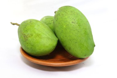 Kil tabakta soyulmamış yeşil mango. Stüdyo fotoğraf çekimi.