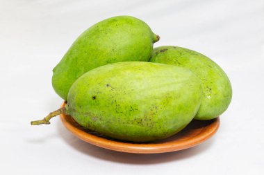 Kil tabakta soyulmamış yeşil mango. Stüdyo fotoğraf çekimi.