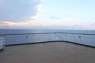 Tahta güverte ve yolcu gemisinden tırabzan. Güzel gün batımı ve okyanus manzarası.