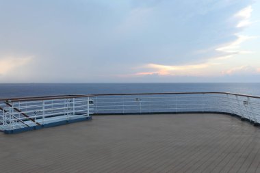 Tahta güverte ve yolcu gemisinden tırabzan. Güzel gün batımı ve okyanus manzarası.