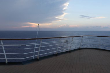 Tahta güverte ve yolcu gemisinden tırabzan. Güzel gün batımı ve okyanus manzarası.