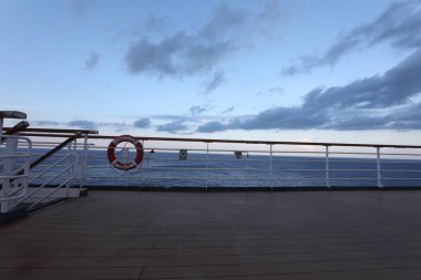 Tahta güverte ve yolcu gemisinden tırabzan. Güzel gün batımı ve okyanus manzarası.