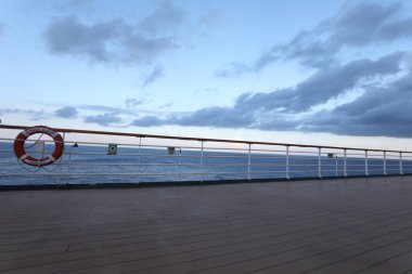 Tahta güverte ve yolcu gemisinden tırabzan. Güzel gün batımı ve okyanus manzarası.