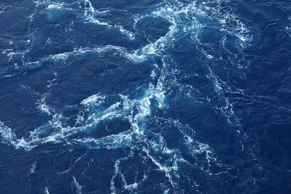 Frothy trail behind the boat on the ocean.