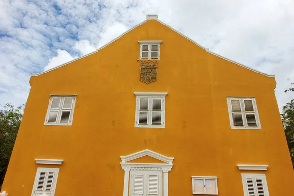 A Yellow Government Building in Bonaire with flag