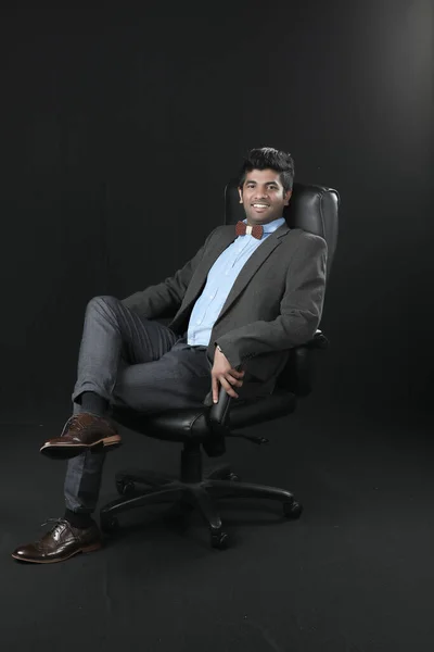 Portrait Young Businessman Sitting Chair Looking Camera Isolated Black Background – stockfoto