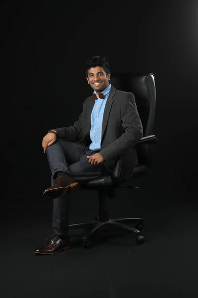 Portrait Young Businessman Sitting Chair Looking Camera Isolated Black Background – stockfoto
