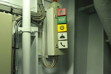 Cruise ship engine room interior with water tight doors electrical and diesel engines, water pipes, measuring instruments, warning signs