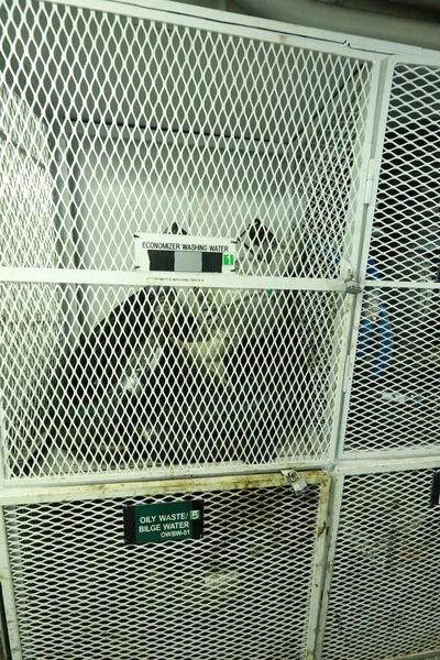 Sintine pompası. Sintine pompasına yakın çekim, su geçirmez kapıları, dizel motorları, su boruları, ölçümleri olan gemi makine dairesini dolaşın.