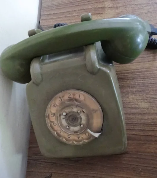 Vintage telephone on old table sepia photo