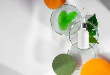 Poliglutamik asit, derin su ve yüz bakımı için. Yeşil yapraklı ve suyu olan petri kapları. Renkli turuncu kağıtlı ve gölgeli bir arka plan. Yeni güzellik kavramı anti yaş eğilimi. Boşluğu kopyala